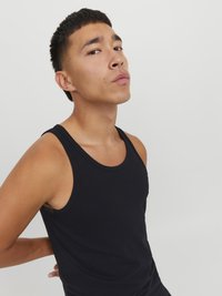 Débardeur en coton noir avec un design sans manches, présentant un col rond et une texture lisse. Style simple et polyvalent.