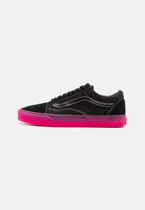 Niski czarny sneaker z białym przeszyciem i jasnoróżową przezroczystą podeszwą, pokazany z boku na białym tle.