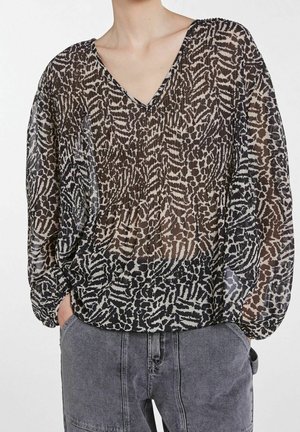 Chemisier noir transparent avec un décolleté en V, présentant un motif abstrait blanc et beige, des manches longues bouffantes et un ourlet froncé.