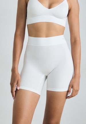 Hvite, stretchy shorts med høy midje, glatt tekstur og en tettsittende design, egnet for aktivitet eller avslapning.