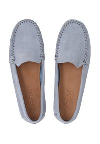 Helle blaue Wildleder-Slipper mit kontrastierenden Stichen, flachem Design und einer glatten, tanfarbenen Innensohle, die mit einem eingeprägten Logo versehen ist.
