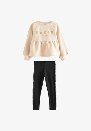 Sudadera rosa con "BAKER" en letras doradas, combinada con leggings negros que tienen rayas laterales con texto del logo. Tejido suave y casual.