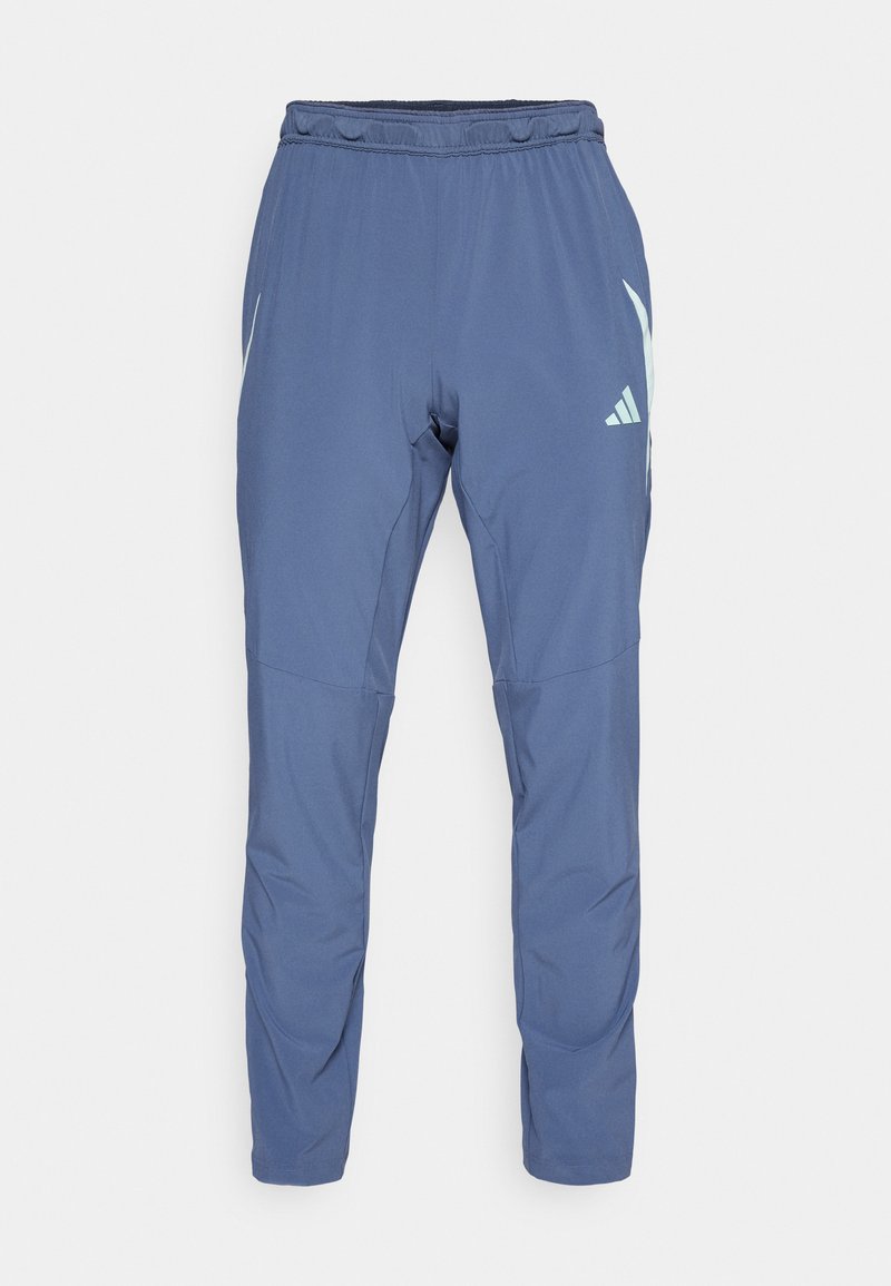 Dunkelblaue Sporthose aus leichtem Material mit elastischem Bund, schmal zulaufendem Bein und einem weißen Markenlogo an der Seite.