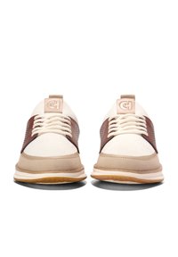 Béžové a hnědé tenisky s texturovanou tkaninou, šněrovacím designem a gumovou podrážkou. Obsahuje detail loga na jazyku a bočních panelech.