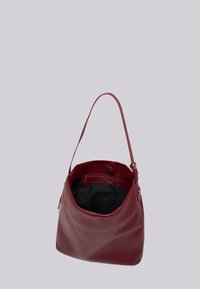Torba hobo z burgundowej skóry z pojedynczym uchwytem, miękką fakturą oraz przestronnym wnętrzem, w którym znajduje się kieszeń na zamek i czarna podszewka.