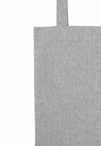 Grijze stoffen draagtas met een enkele handgreep, dicht bij de bovenkant weergegeven tegen een witte achtergrond.