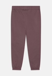Měkké, pružné jogger kalhoty v barvě lilek s elastickým pasem, zúženými manžetami a hladkým povrchem. Žádné viditelné vzory nebo kovové prvky.