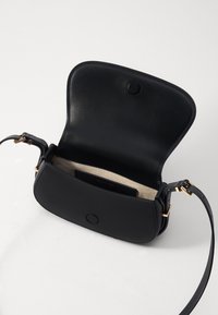 Svart lädercrossbodyväska med magnetstängning, detaljer i guldton, beige innerfoder och en smal justerbar axelrem.