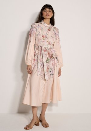 Langärmeliges Kleid mit Blumenmuster aus weichrosafarbenem Stoff. Es verfügt über eine durchgehende Knopfleiste, eine taillierte Passform mit passendem Gürtel und einen fließenden Rock.