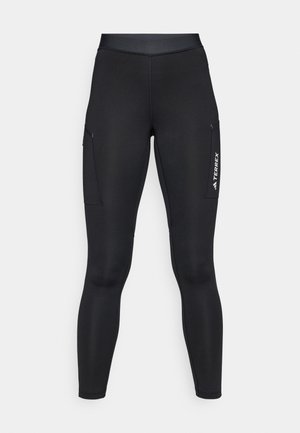 Zwarte sportleggings met een aansluitend ontwerp, gemaakt van rekbaar materiaal. Voorzien van zijzakken en witte "TERREX" branding.