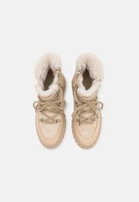 Botas de ante beige con un forro de crema suave, diseño de cordones y suela de goma. Presentan cremalleras y acentos de metal.