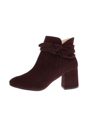 Dark brown suede ankle boot with block heel and decorative twisted strap detail around the ankle.