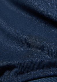 Marineblaues Gewebe mit einem subtilen Glitzern, das eine glatte Struktur und feine Webart aufweist. Das Material wirkt leicht und leicht reflektierend.