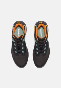Scarpe sportive nere con parte superiore in rete, accenti verdi e arancioni, lacci tondi, colletto imbottito e logo distintivo laterale.