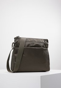 Kabelka přes rameno z olivově zeleného nylonu s texturovaným povrchem, horním zipem, nastavitelným popruhem a přední kapsou. Stříbrné kovové doplňky.