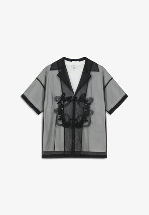 Camiseta negra de manga corta con cuello, que presenta un intrincado bordado negro y cierre de botones en el frente. Tela delgada y transparente.