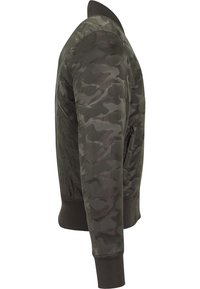 Veste bomber camouflage dans des tons de vert sombre, réalisée en tissu lisse. Dotée de poignets et d'un col côtelés, avec une poche latérale zippée.