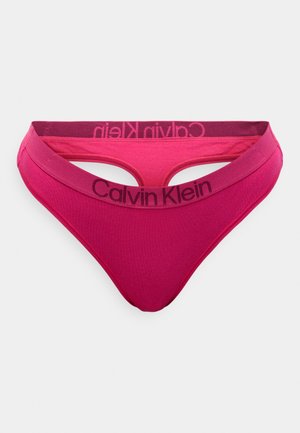 Calvin Klein pink thong, featuring a soft fabric, low-rise design, and a contrasting waistband with brand logo in dark purple.