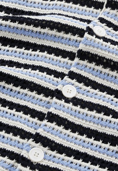 Crochet takki, jossa on vaakasuoria raitoja mustassa, valkoisessa ja vaaleansinisessä, neljä muovista nappia ja teksturoitu kuvio.