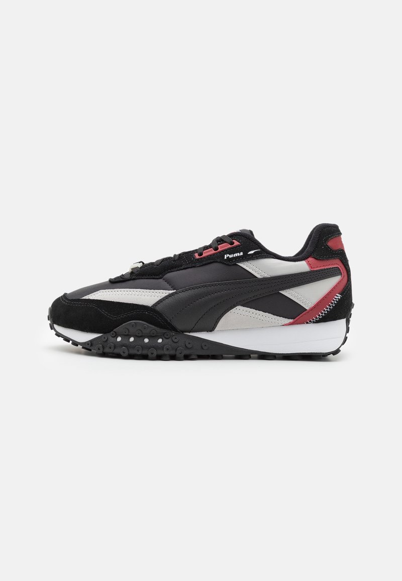 Baskets Puma noires, grises et rouges avec semelle texturée, fermeture à lacets et logo Puma sur le côté.
