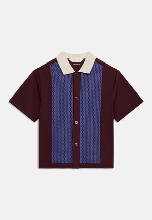 Kortærmet burgundy skjorte med knapper, hvid krave og lodret blå kæde-mønster på frontpanelerne.