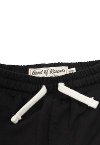 Svarta shorts med elastiskt midjeband och vita dragband. Har varumärkesetikett "Band of Rascals" på en krämfärgad bakgrund. Mjukt, bomulls material.
