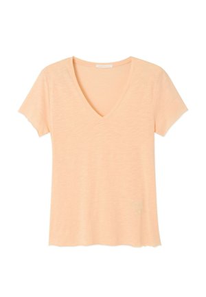 Lahka breskvasto obarvana majica s kratkimi rokavi in V-izrezom, narejena iz mehke tkanine z rahlo valovitimi robovi na rokavih in spodnjem robu.