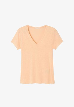 Lahka breskvasto obarvana majica s kratkimi rokavi in V-izrezom, narejena iz mehke tkanine z rahlo valovitimi robovi na rokavih in spodnjem robu.