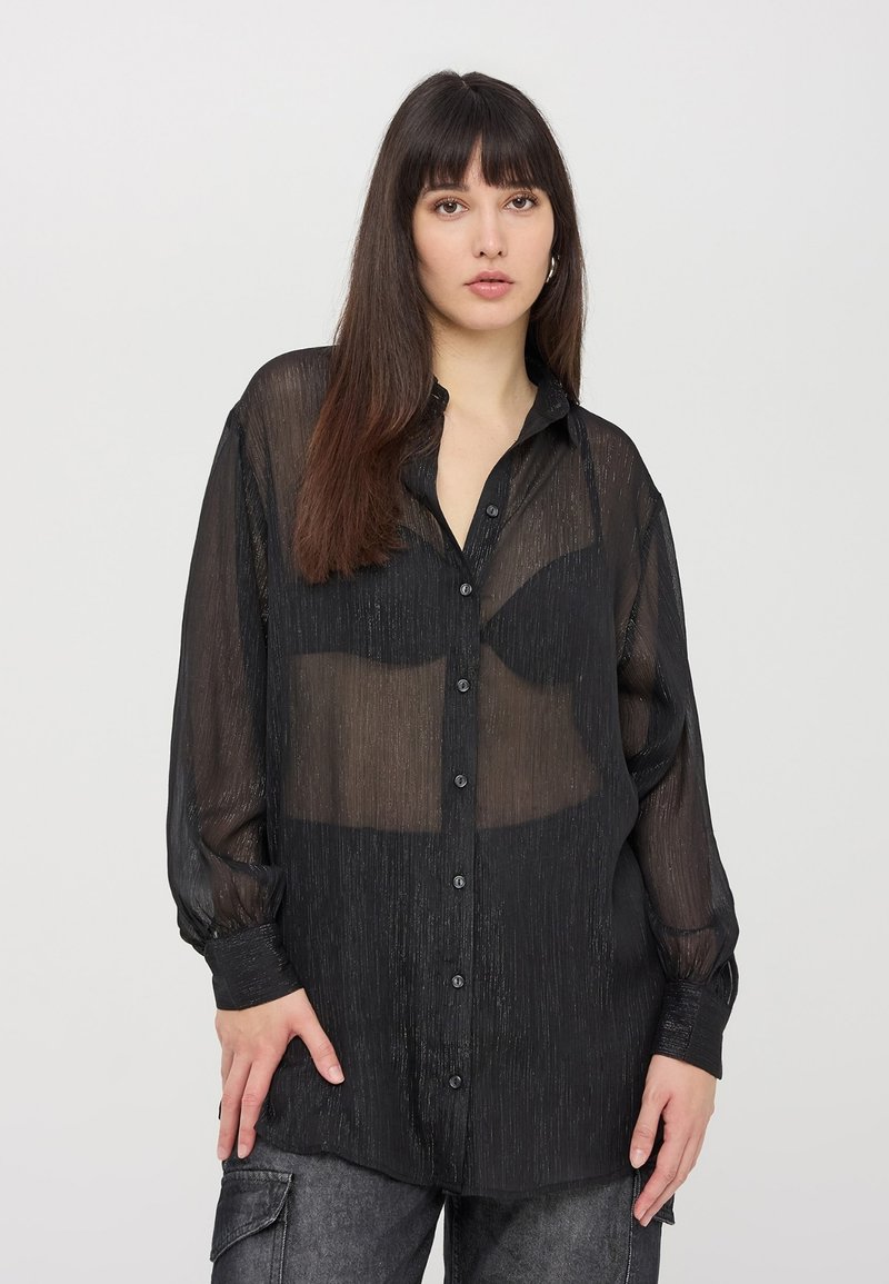 Camicia nera trasparente con bottoni, maniche lunghe, sottili righe verticali e vestibilità rilassata. Presenta un colletto classico e bottoni neri.