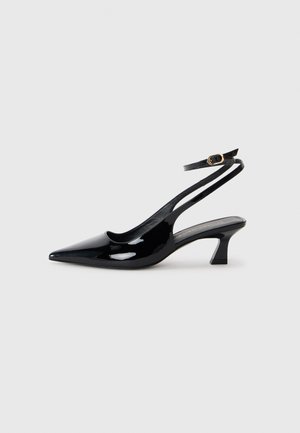Black patent leather slingback heels with pointed toe, low block heel, and adjustable ankle strap featuring a gold buckle.