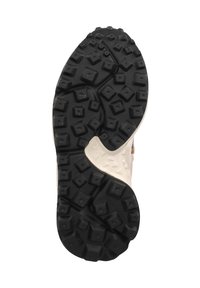 Black rubber outsole with multidirectional lugs for traction, featuring a beige midsole with a textured, raised design.