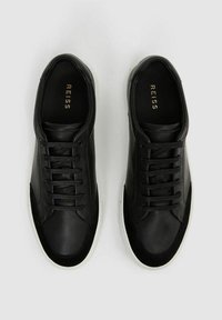 Sneaker nere in pelle con una texture liscia, dotate di un design con lacci, suola in gomma bianca, accenti in suede e branding dorato all'interno.