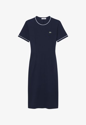 Navyblauwe jurk tot op de knie met korte mouwen, witte bies aan kraag en mouwen, en een klein groen krokodillenlogo op de borst.