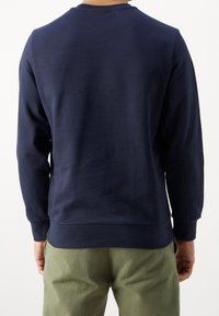 Mörkblå bomullströja med rund hals, långa ärmar och ribbad nederkant. Slät textur, enkel design, inga synliga mönster eller logotyper.