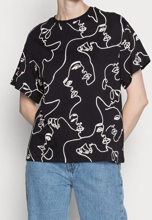 T-shirt noir avec des dessins de visages abstraits en ligne blanche ; manches courtes, col rond, coupe décontractée, texture en coton lisse.