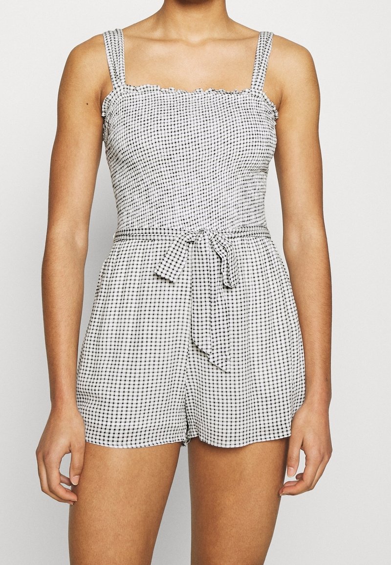 Zwart-wit geruit romper met een vierkante halslijn, geruite bandjes en een taille met riem. Lichtgewicht stof met een aangesloten pasvorm.