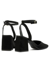 Czarne zamszowe buty na obcasie o prostokątnym kształcie z paskiem na kostkę. Otwarty nos, teksturowany materiał zamszowy i jednolity czarny kolor. Uzupełnione złotą klamrą.