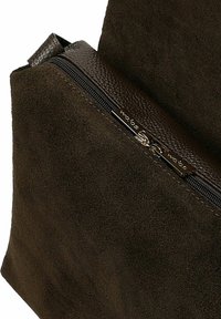 Borsa in pelle scamosciata marrone con finitura strutturata, dotata di chiusura con cerniera e dettagli hardware lucenti. Il design è angolare e strutturato.