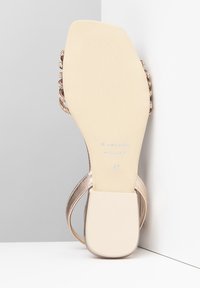 Rosa-goldfarbene High-Heels aus glattem, glänzendem Material, mit offenem Rücken und dekorativen Edelsteinakzenten. Flache, strukturierte Sohle mit der Größe 37.