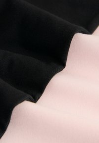 Zwart en lichtroze stof gevouwen, met een gladde textuur en een subtiele glans in contrasterende kleuren. De randen zijn netjes afgewerkt.