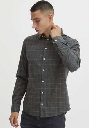 Camisa de cuadros gris abotonada hecha de tela texturizada, con cuello regular y mangas largas con puños abotonados.