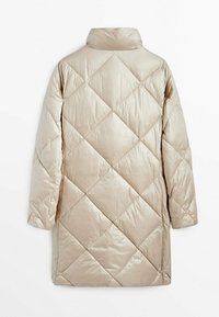 Long manteau matelassé beige avec piqûres en forme de losange, col montant et manches longues, vu de dos sur un fond blanc.