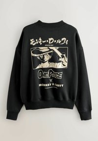 Czarna bluza z okrągłym dekoltem, z dużą grafiką postaci trzymającej miecz. Biały napis zawiera "ONE PIECE" i "MONKEY D. LUFFY."