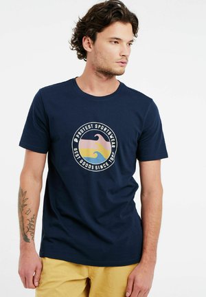 Marineblauwe katoenen t-shirt met een circulaire grafiek van gestileerde golven in roze, geel en blauw; ronde halslijn, korte mouwen.