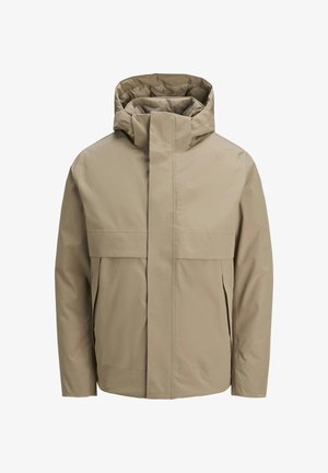 Giacca impermeabile beige con cappuccio, dotata di una zip frontale, grandi tasche con patta e un design minimalista. Texture liscia e taglio moderno.