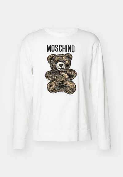Sweatshirt à manches longues blanc avec un graphique en forme d'ours en peluche noir et marron et le texte "Moschino" au-dessus. Matière en coton, poignets côtelés.