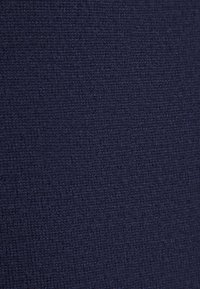 Tessuto di un blu scuro con una texture dal motivo intrecciato, che presenta una finitura leggermente a coste. La superficie appare uniforme e consistente in tutto.