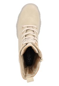 Botín beige hasta el tobillo con exterior de ante, forro de piel sintética en color crema, punta redonda, cierre de cordones en la parte delantera y detalle de cremallera lateral para facilitar su uso.