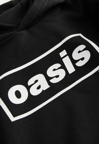 Čierna mikina s kapucňou a veľkým bielym obdlžníkovým logom s nápisom "oasis". Vyrobená z látky s hladkou textúrou a štandardným dizajnom kapucne.