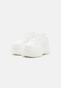 Zapatillas chunky blancas con una suela de goma texturizada, diseño con cordones y parte superior que proporciona soporte. Incluye detalles del logo en la lengüeta y el costado.